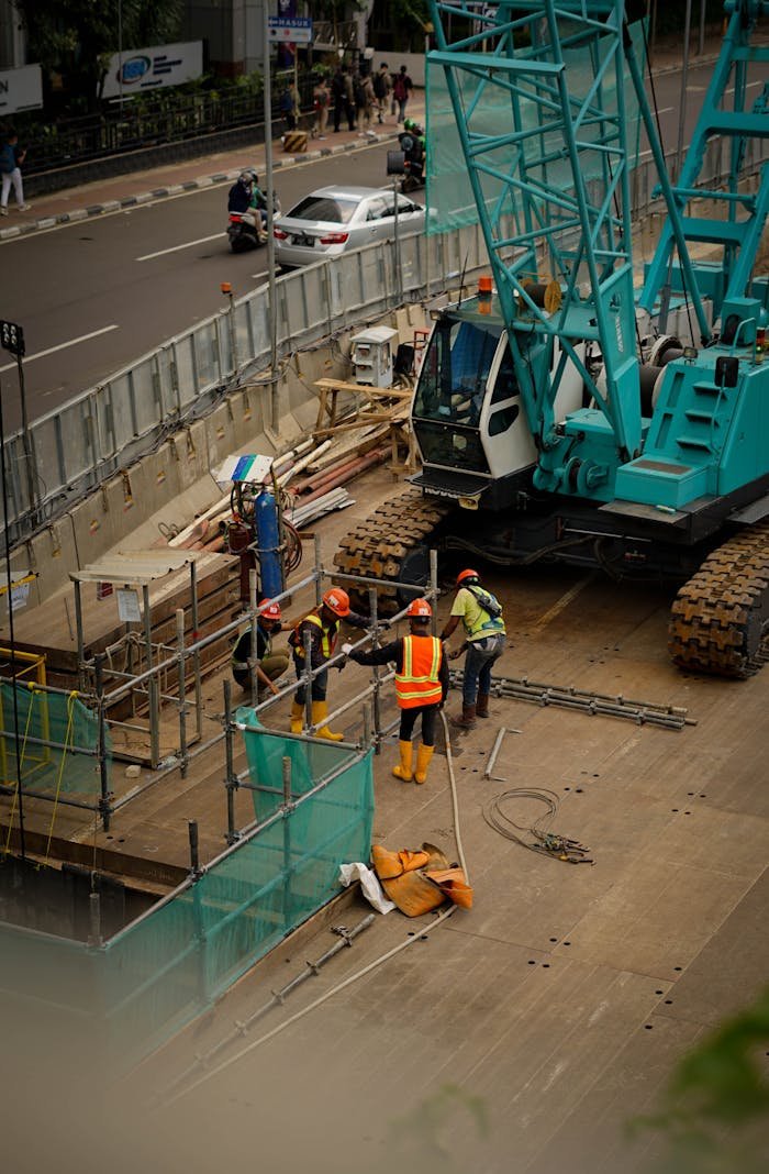 A bustling construction site in Jawa Barat, Indonesia featuring workers and machinery.